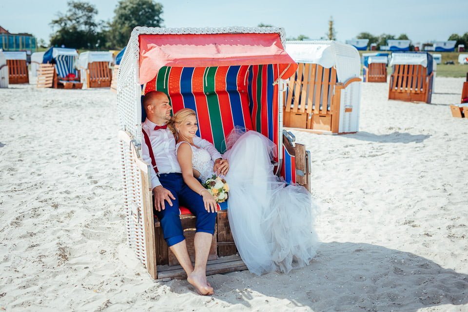 Hochzeitspaar sitzt im Strandkorb am Strand von Schillig