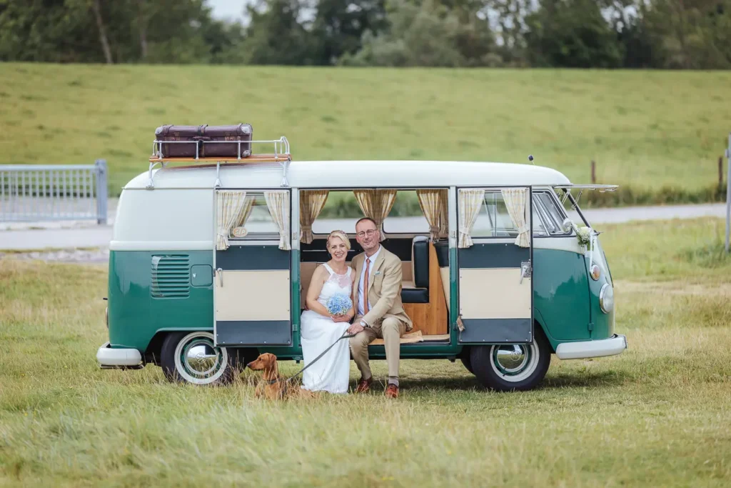 Hochzeitspaar im VW Bus am Strand von Hooksiel